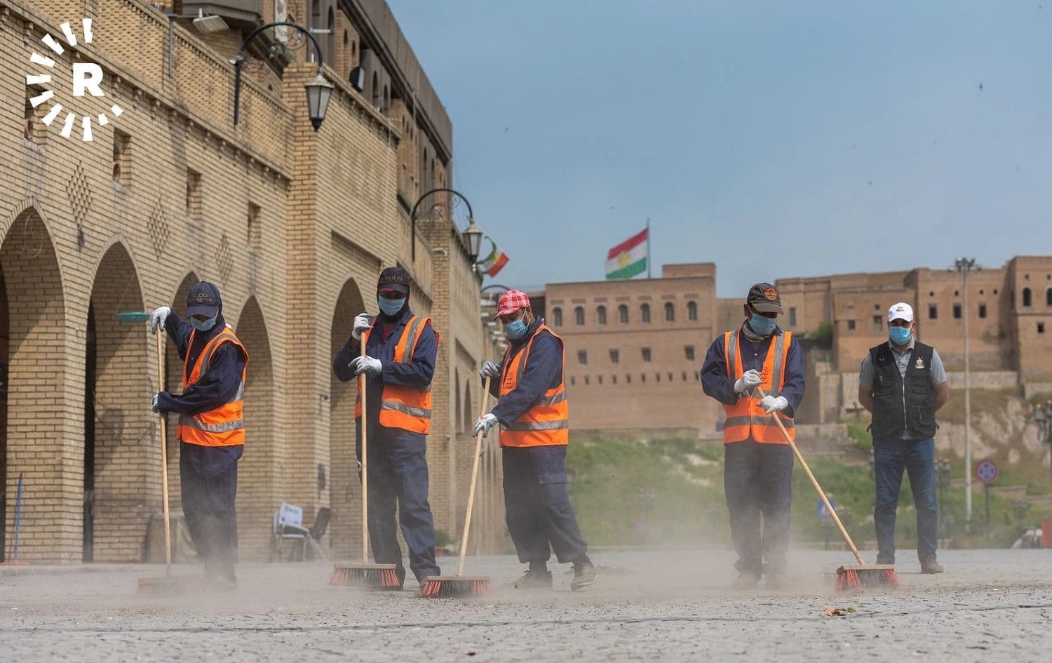 Workers wearing face masks sweep the cobblestones at Erbil’s central bazaar. Photo: Bilind T. Abdullah/Rudaw