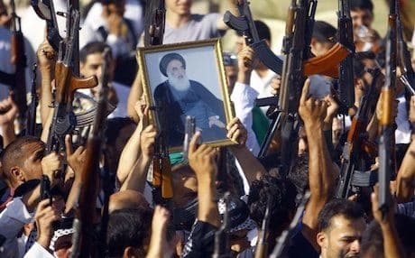Iraqi Shiites holding a poster of Ayatollah Ali al-Sistani in Najaf on Tuesday, answering the call for taking up arms against the Sunni militants. Photo: AFP
