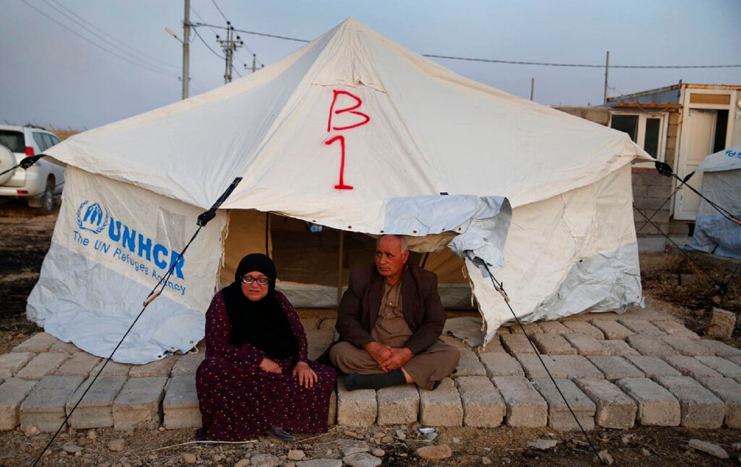 A Syrian couple sits it in front of a tent upon their arrival at the Bardarash camp, Duhok province on Oct 16, 2019. Photo: Hussein Malla/AP