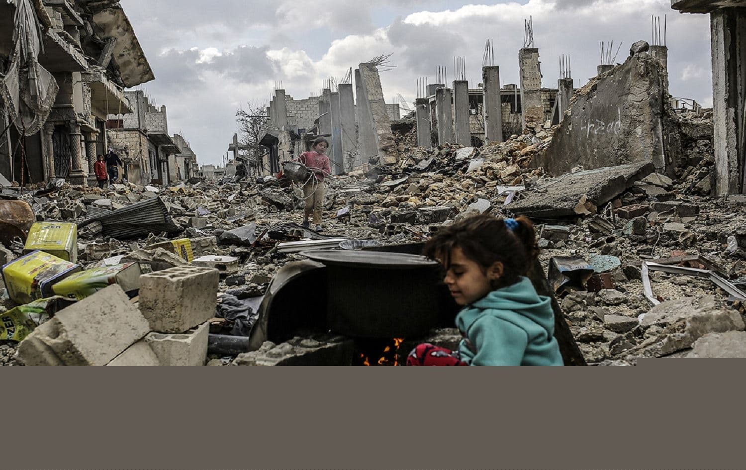 Kurdish Syrian girls play in the ruins of Kobane. Photo: Yasin Akgul/AFP