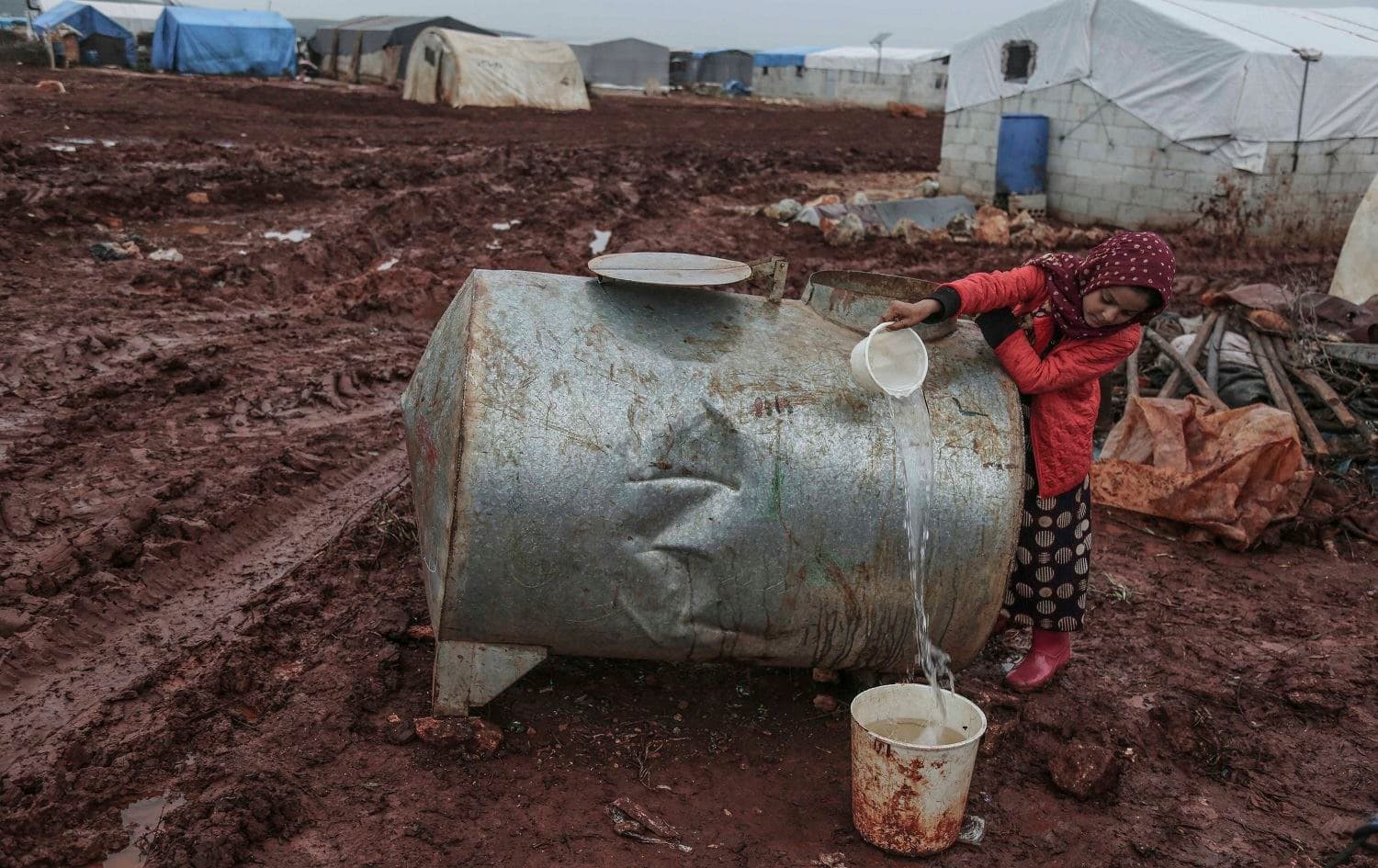 A displaced Syrian girl fills water from a cistern at an IDP camp near the Syrian-Turkish border in Idlib. Photo: Anas Alkharboutli / AP 