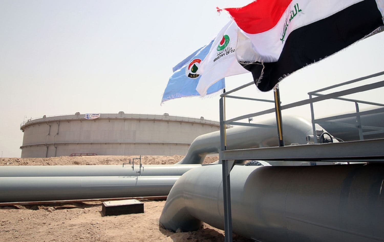 Flags flutter in front of an oil tank at al-Faw storage terminal, southern Iraq. File photo: Haidar Mohammed Ali / AFP