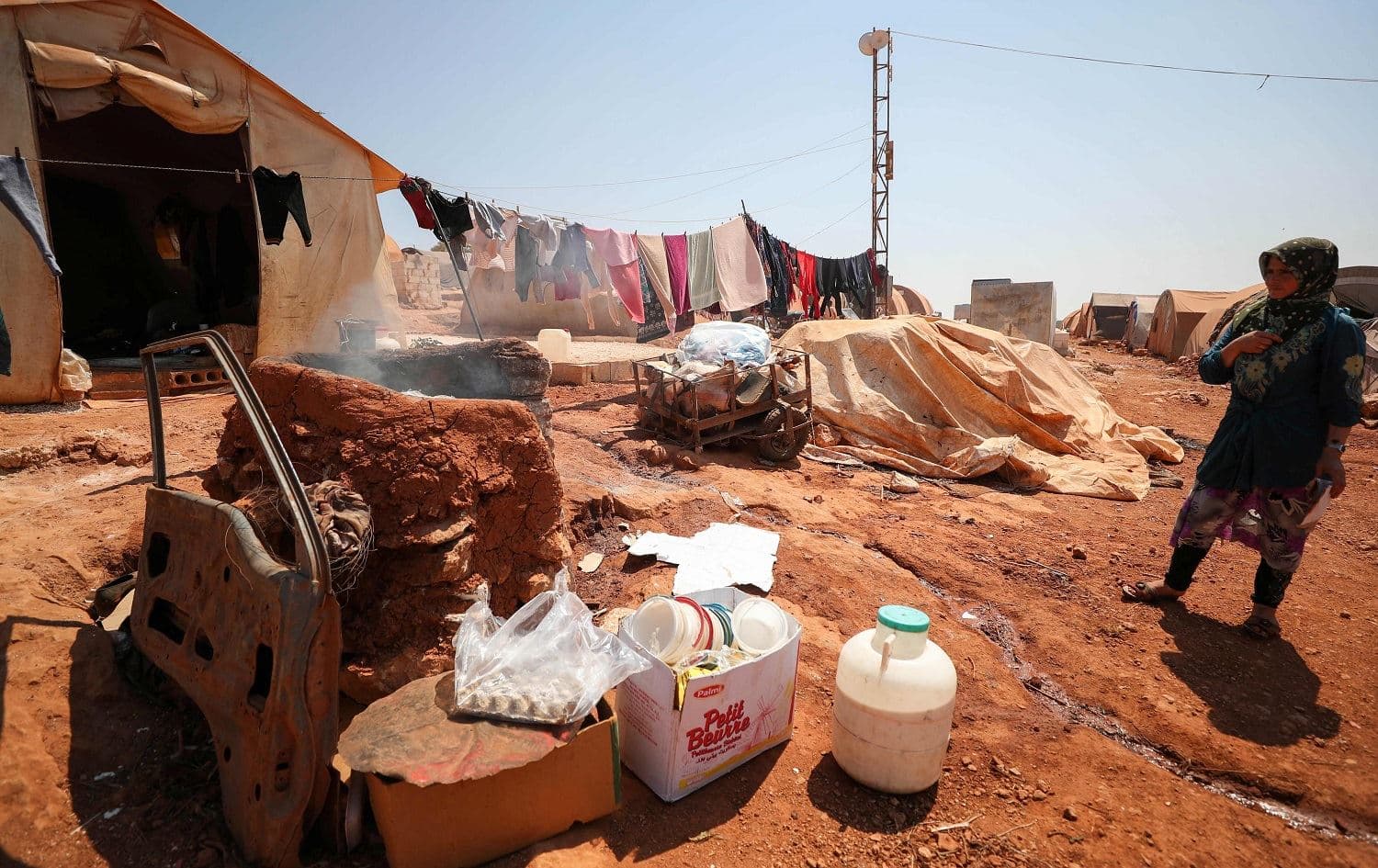 A displaced Syrian woman, stands next to her tent at a camp for displaced Syrians from Idlib and Aleppo provinces, near the town of Maaret Misrin in Syria's northwestern Idlib province on July 11, 2020. Photo: Omar Haj Kadour/AFP