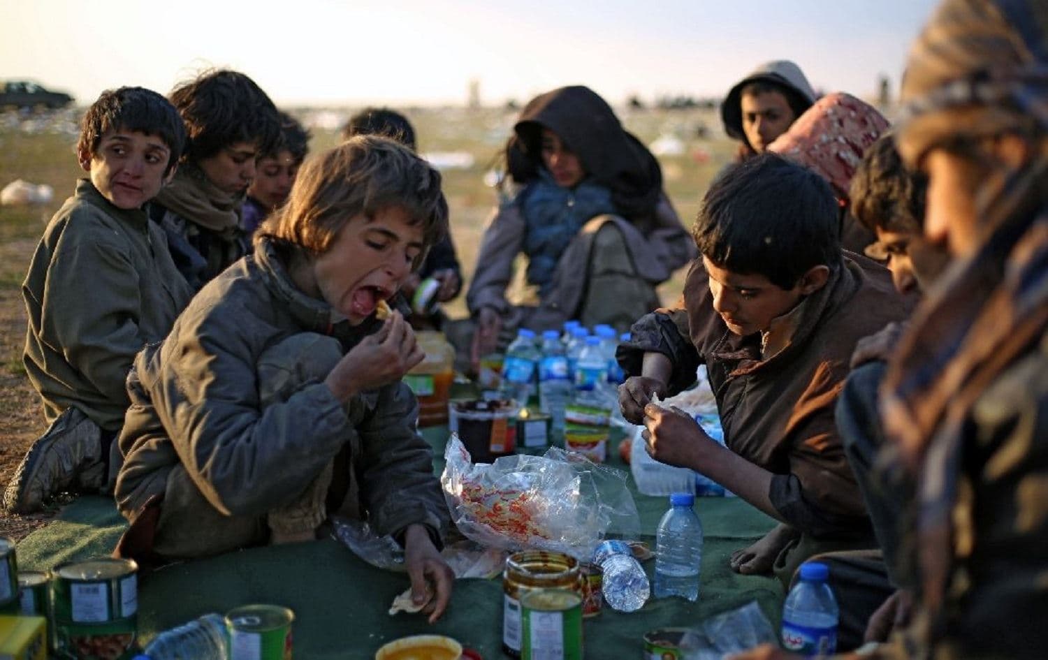 File photo of Yezidi boys sharing a meal in Syrian Democratic Forces-held territory after escaping the last scrap of the Islamic State group's collapsed "caliphate." Photo: AFP