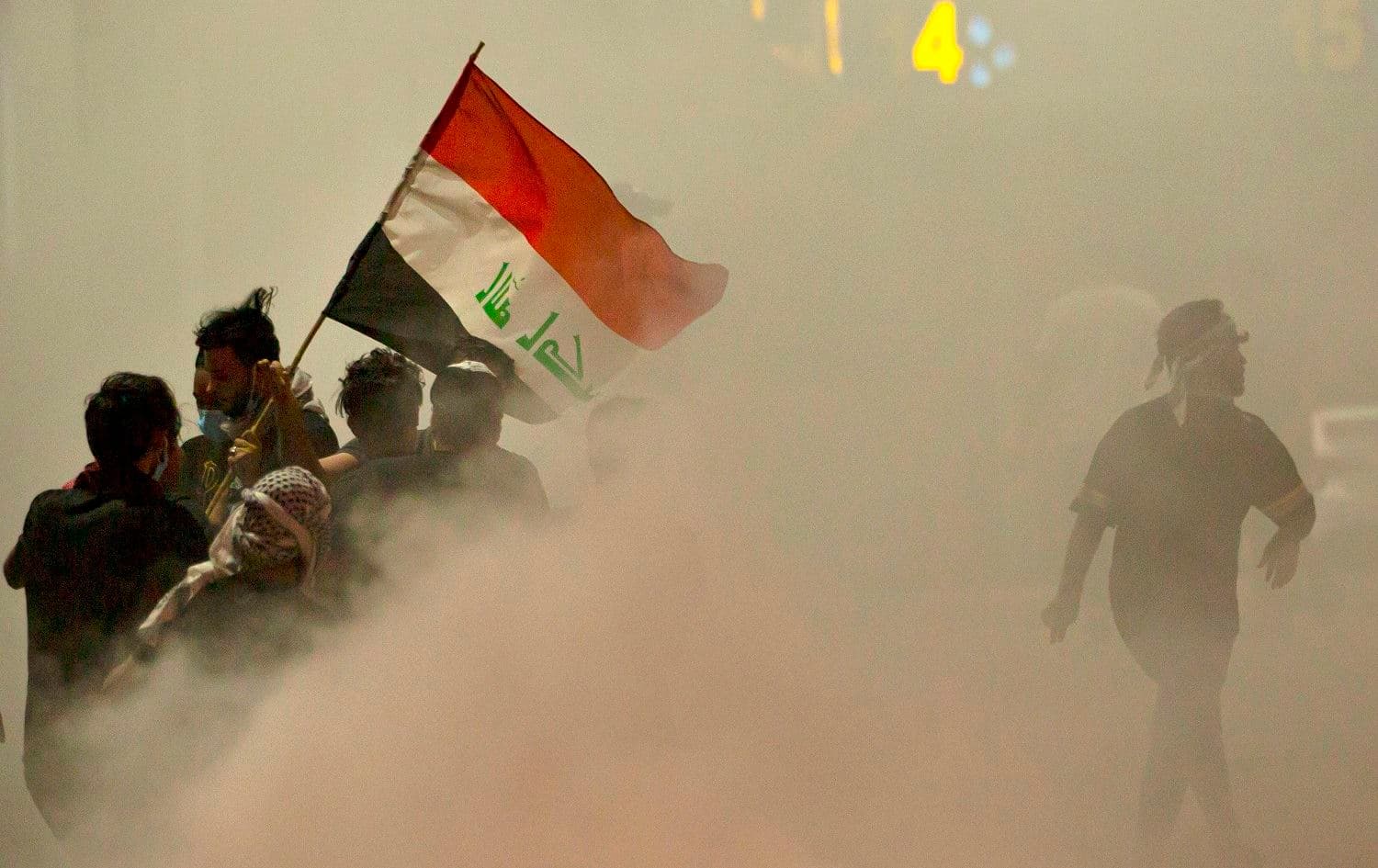 Iraqi demonstrators gather amid smoke after fire services extinguished burning tires during a protest near the governor's residence in the southern city of Basra, to oppose assassinations and demand the resignation of top security officials on August 17, 2020. Photo: Hussein Faleh/AFP
