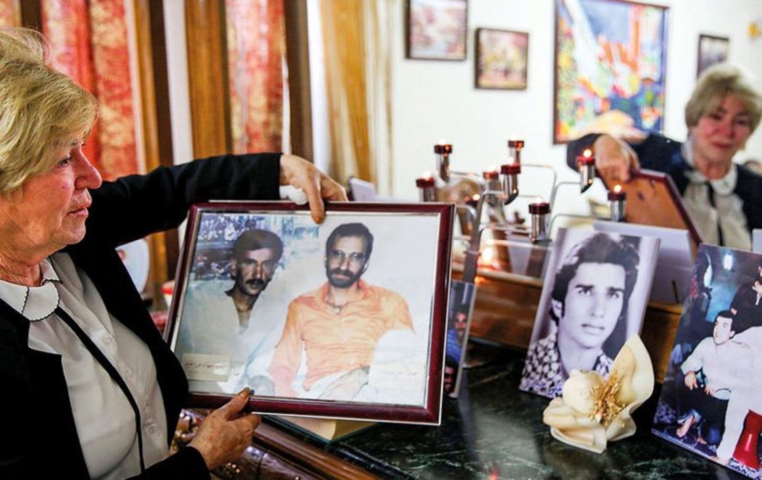 Samya Khasro, a woman from Iraq’s Shiite Kurdish minority, displays pictures of family members who disappeared 35 years ago in Baghdad last month. Photo: AFP