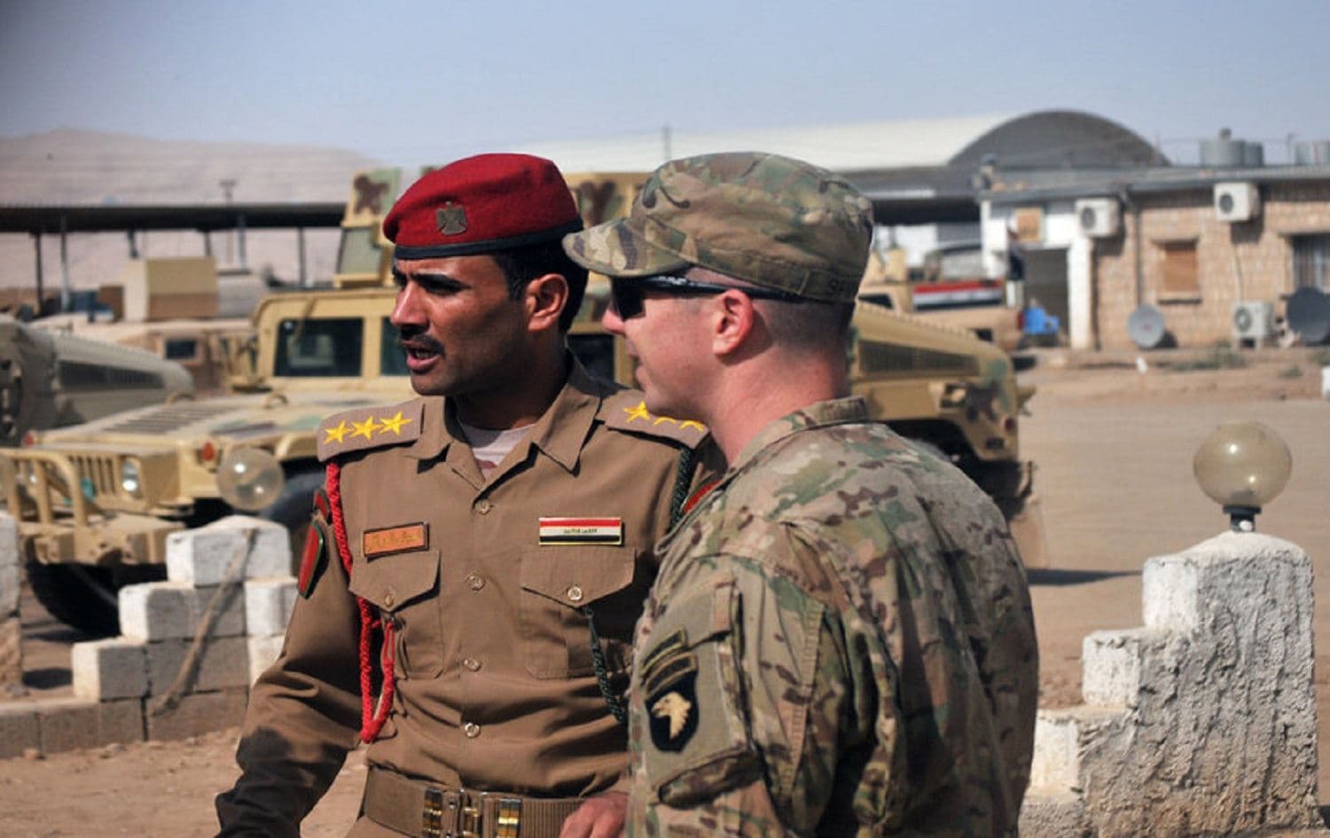 U.S. Army Capt. Gerrard Spinney (right) speaks to his Iraqi army counterpart from the Nineveh Operations Command prior to a security meeting at Camp Swift, Iraq. Photo: 1st Lt. Daniel Johnson/AP