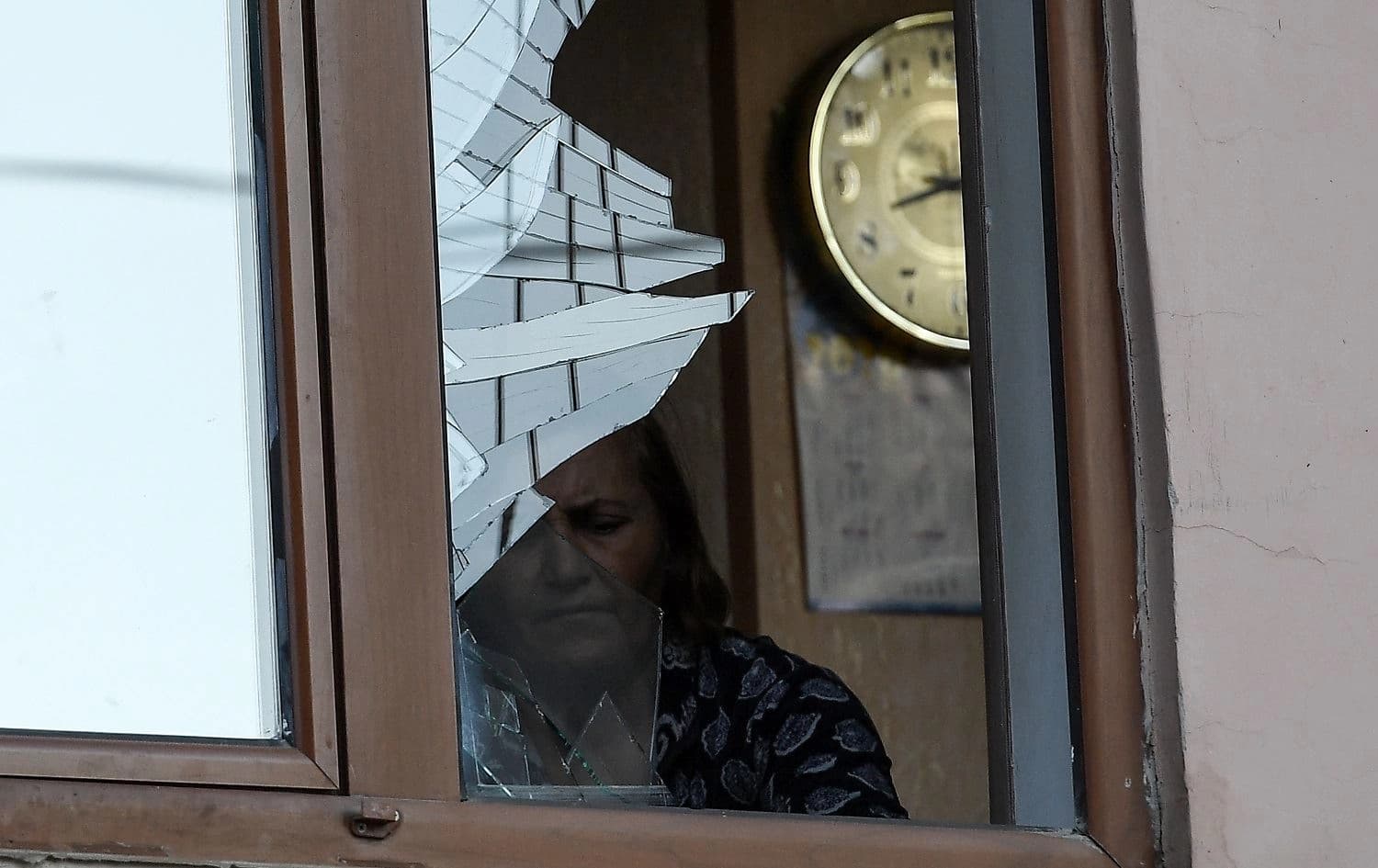 A woman is seen through a broken window in an apartment building that was supposedly damaged by recent shelling in the breakaway Nagorno-Karabakh region's main city of Stepanakert on October 3, 2020. Photo: AFP