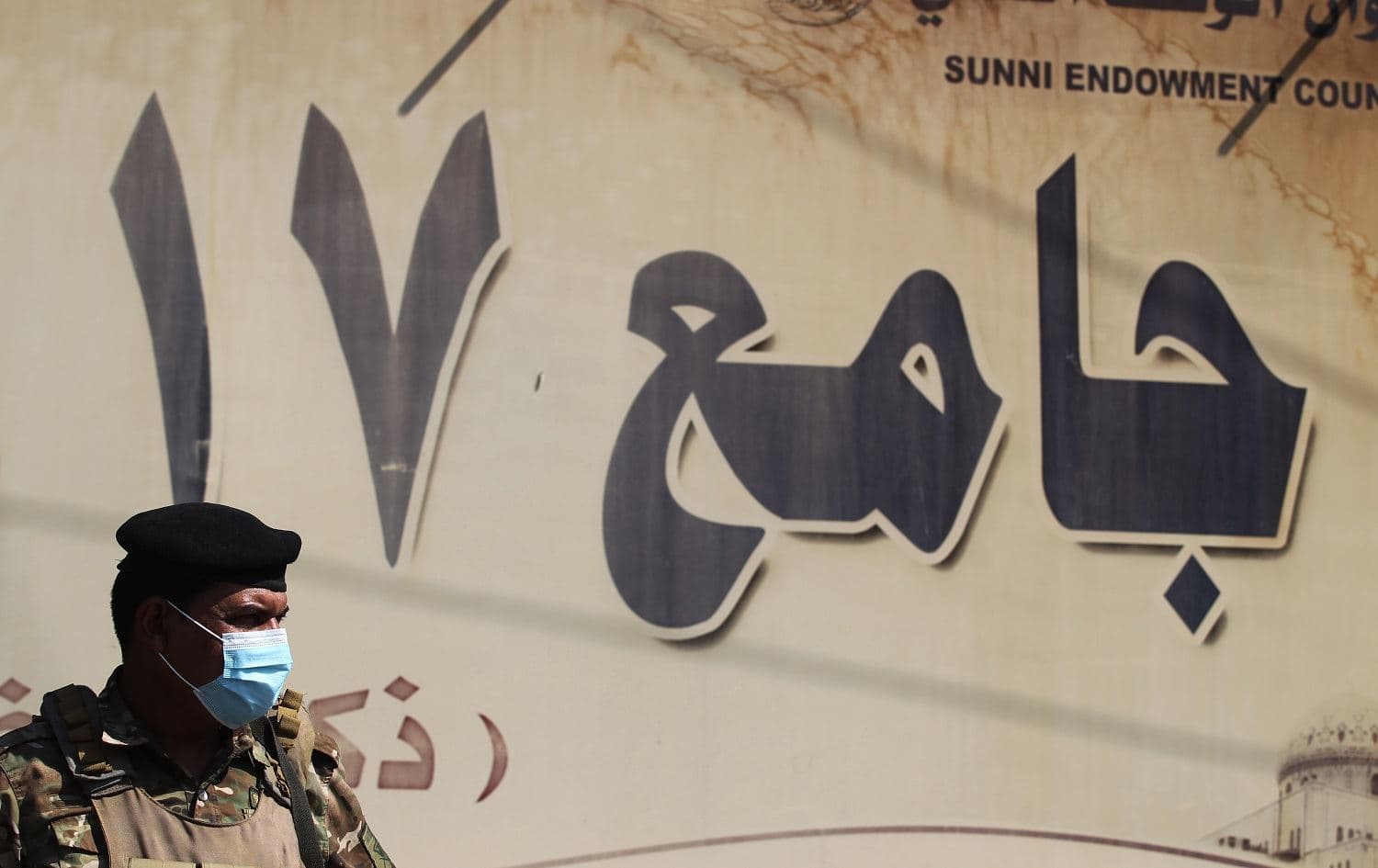 A mask-clad Iraqi security guard (COVID-19 coronavirus pandemic precaution) stands outside a mosque in Baghdad on October 9, 2020. Photo: Ahmad al-Rubaye / AFP