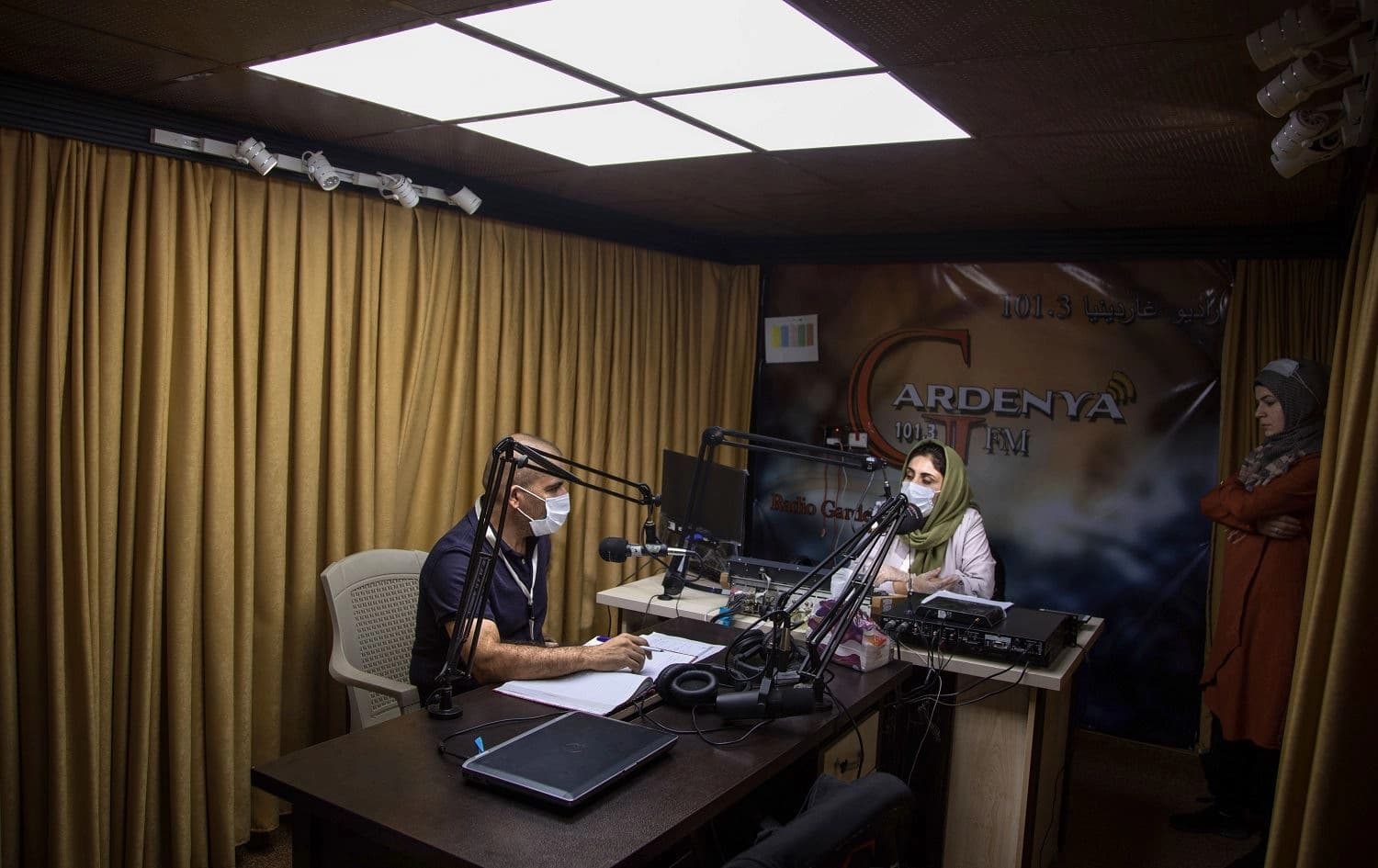 A lawyer chats with his hostess during a talk show at the Gardenya FM radio station studio at the Arbat refugee camp on November 3, 2020. Photo: Florent Vergnes/ AFP