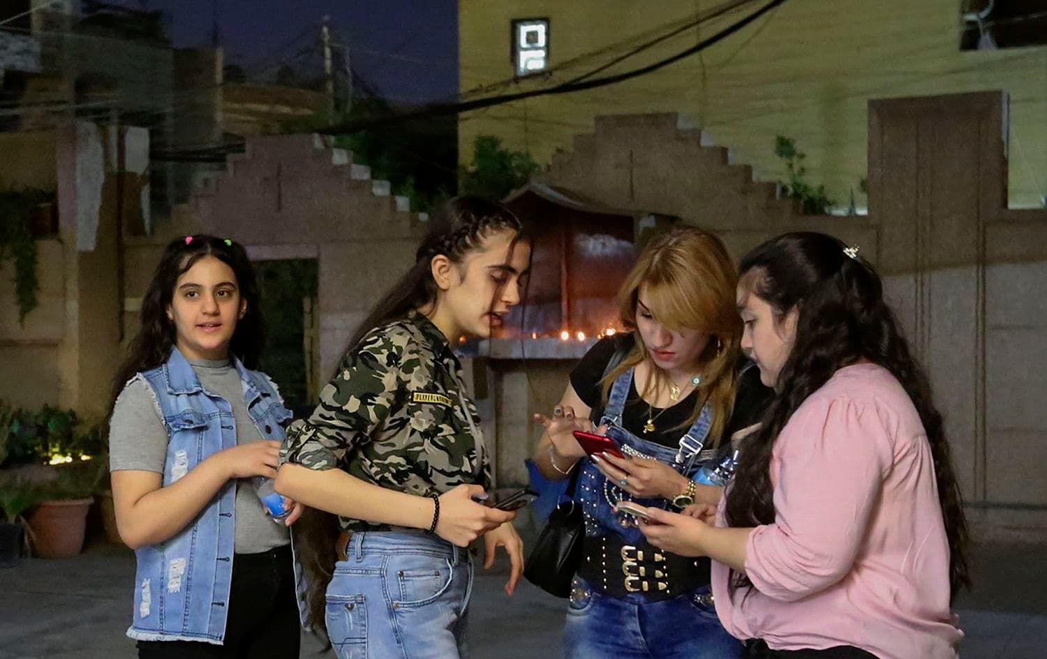 Youths chat in the yard after mass at the Chaldean Church of St. Joseph in the Iraqi capital Baghdad on November 7, 2020. Sabah Arar/ AFP