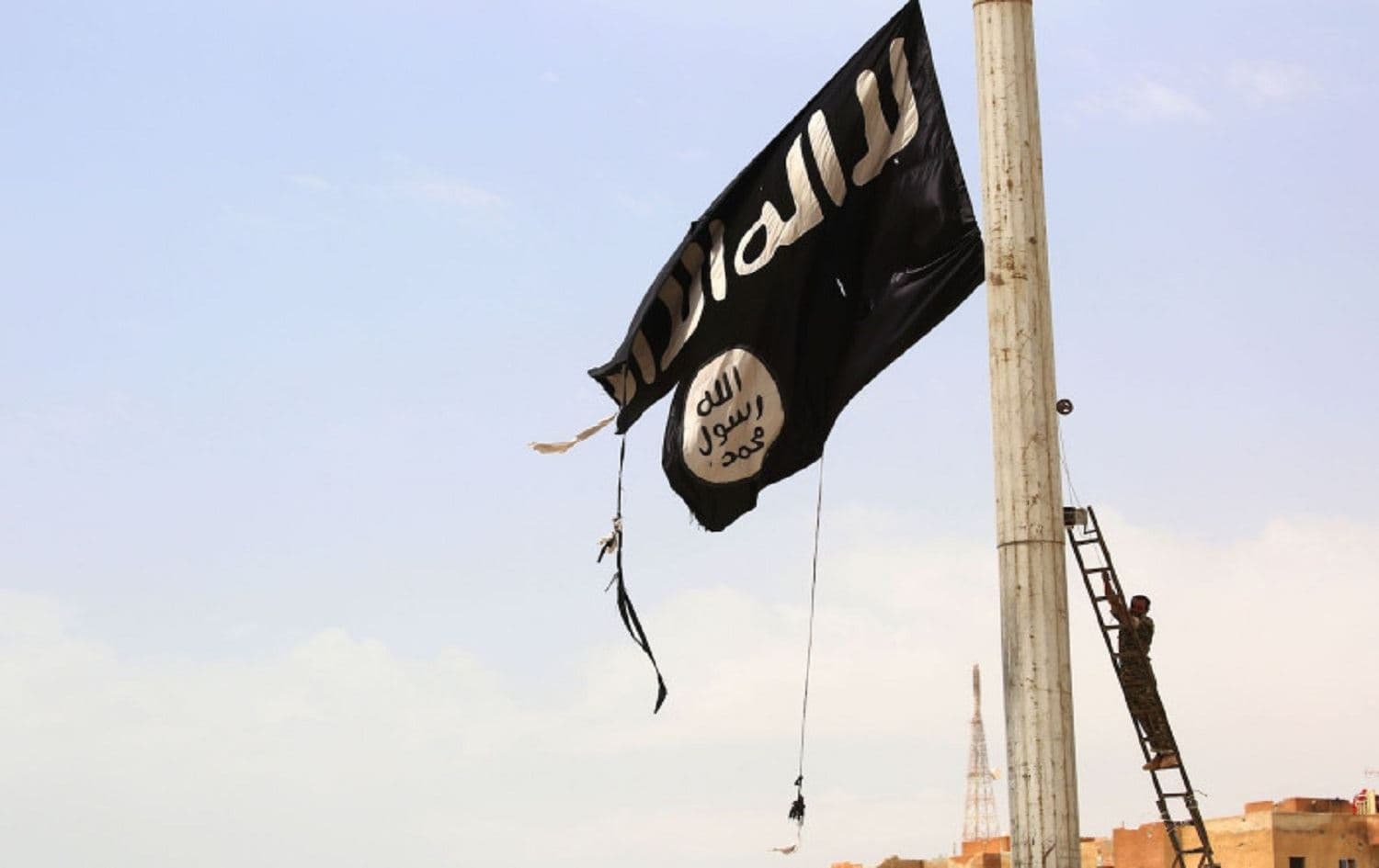 A member of the SDF removes an ISIS flag in the Syrian town of Tabqa on April 30, 2017 Photo: Delil Souleiman/AFP