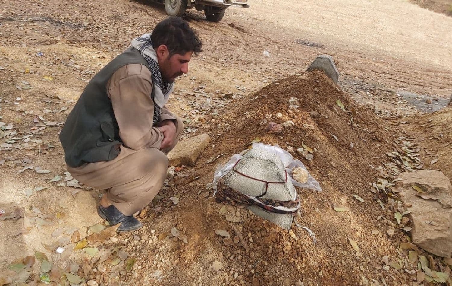 Osman Mamandi sits by his brother Ahmad’s grave in the village of Parastan, Sardasht on November 20, 2020. Photo: Jabar Dastbaz/ Rudaw 