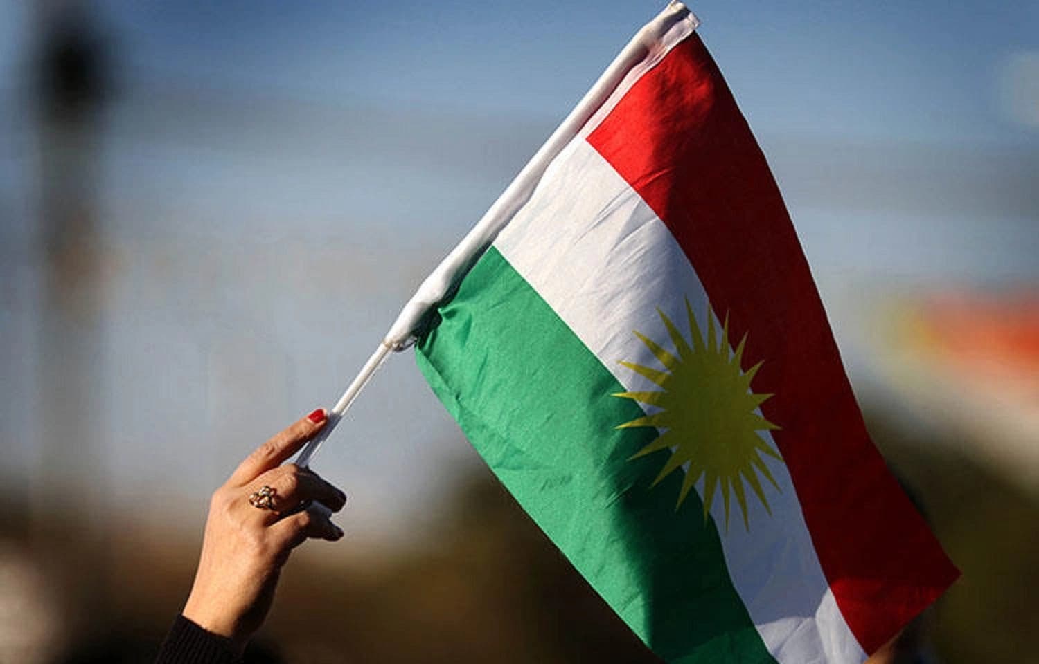 A Syrian Kurd waves the Kurdish flag in Erbil. Photo: Safin Hamed/ AFP