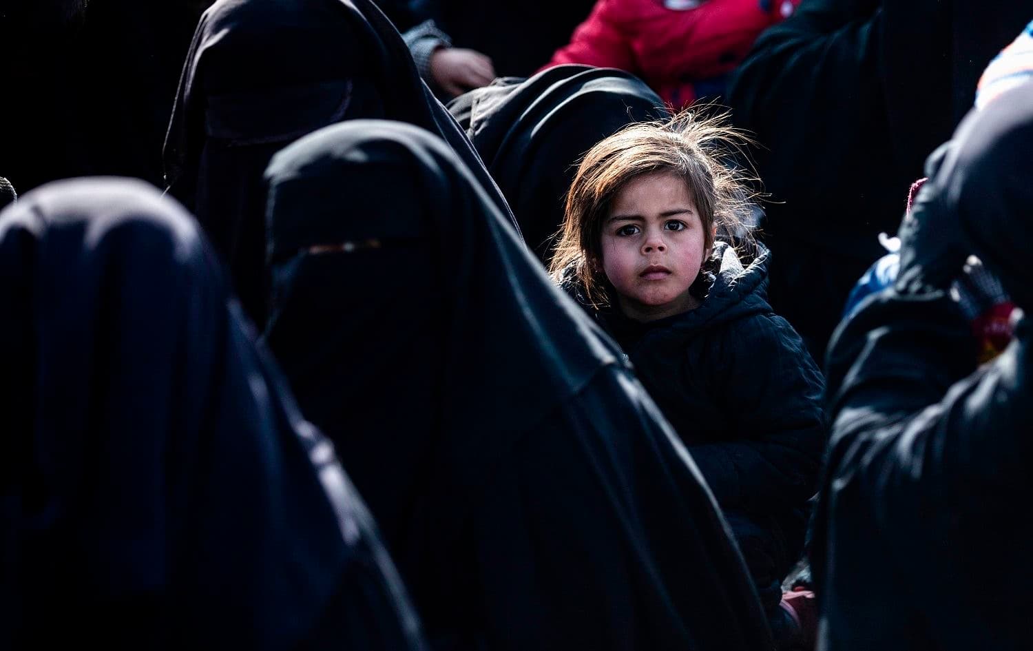 Women lead children ahead of departure during the release of another group of Syrian families from al-Hol camp which holds suspected relatives of Islamic State (ISIS) group fighters, in Hasaka, northeastern Syria on January 28, 2021. Photo: Delil Souleiman/AFP