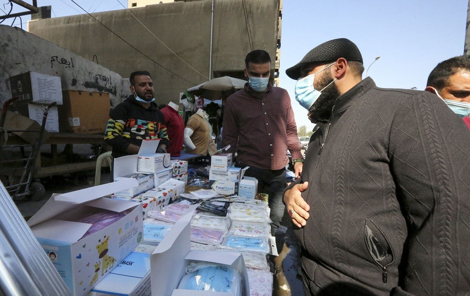 An Iraqi shops for facemasks in the capital Baghdad on February 14, 2021, after the Health Ministry announced it will impose a fine on anyone caught without a mask starting next week. Photo: Sabah Arar / AFP