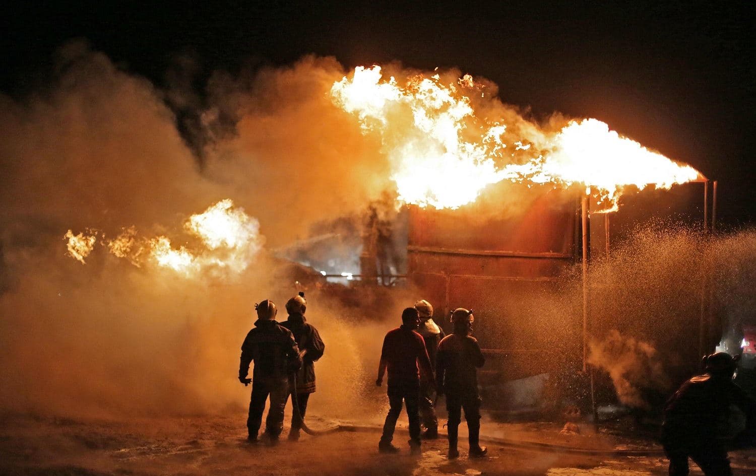 Members of the Syrian Civil Defense (White Helmets) extinguish a fire which reportedly erupted after a bombardment from unknown sources of makeshift oil refining installations in the Tarhin area, near the Turkish-controlled city of al-Bab in the north of Aleppo province, on March 5, 2021. Photo: Aref Tammawi/AFP
