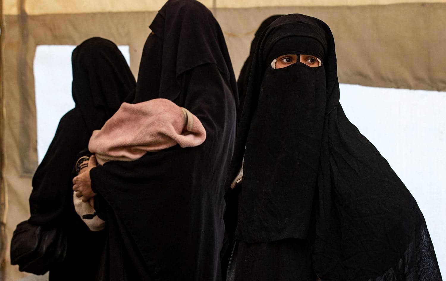 Women, one holding a child, are pictured in northeast Syria’s al-Hol camp on March 18, 2021. File photo: Delil Souleiman/AFP