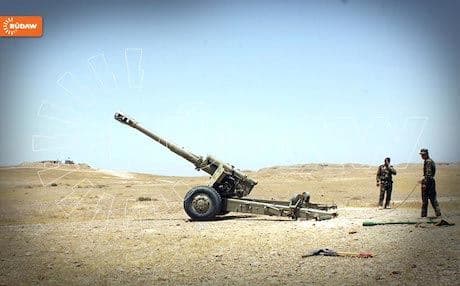 Two Peshmerga soldiers man an artillery gun in Shengal.