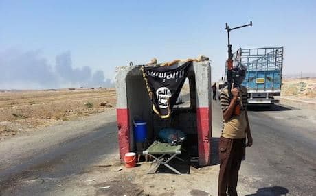 An IS fighter stands guard at a checkpoint near the Baiji refinery. Photo: AP