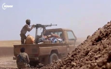 A Peshmerga soldier aims his gun in fighting outside Mosul.