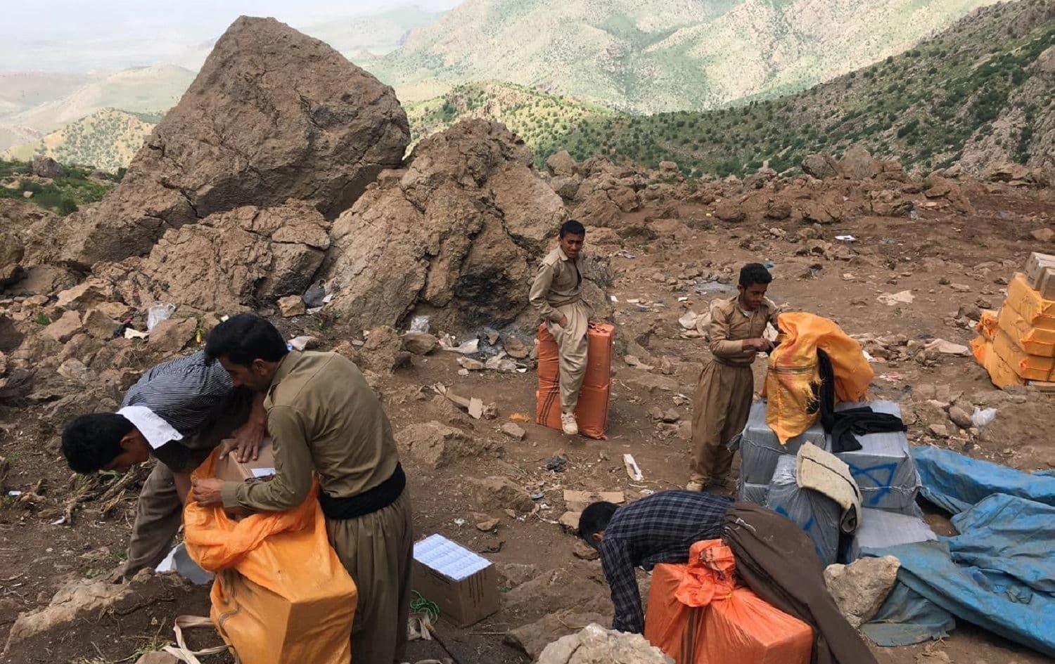Kolbars adjust their loads high in the Hawraman mountains on the Kurdistan Region-Iran border on May 12, 2017. Photo: Fazel Hawramy/Rudaw