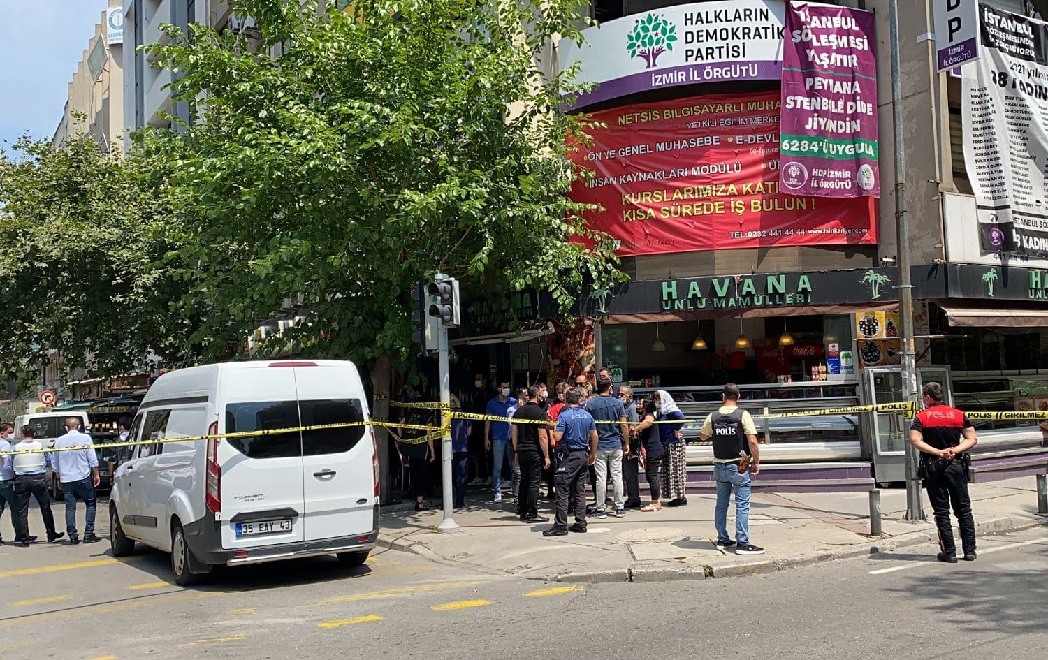 People and police gather outside a building housing offices of the HDP in Izmir where one woman was killed on June 17, 2021. Photo: Anadolu Agency