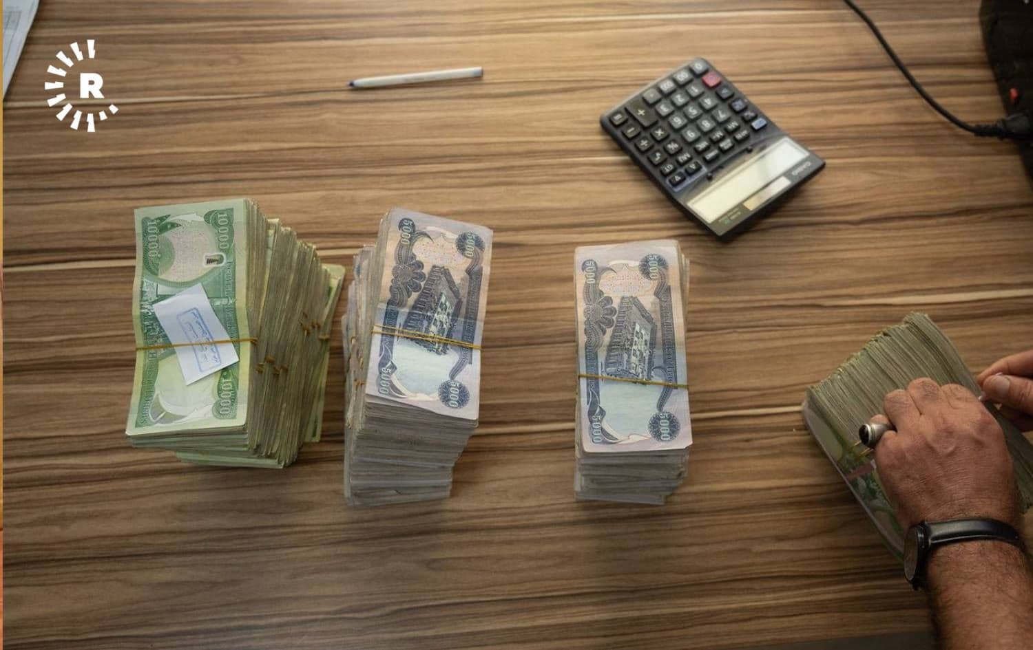 An employee of an Erbil bank counts stacks of dinar notes. Photo: Bilind T. Abdullah/Rudaw