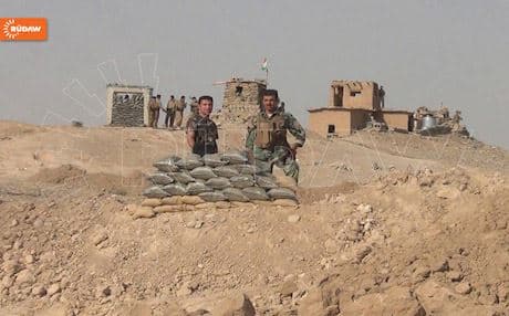 Peshmerga soldiers posing behind a sand-bag position in Kirkuk.