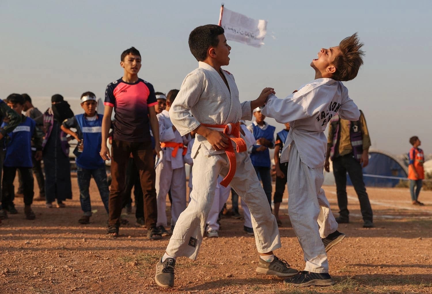 Displaced Syrian boys in karate outfits square off against each other, during the so-called "Camp Olympics 2020" in the town of Fuaa, in the northwestern Syrian last major rebel bastion of Idlib, on August 7, 2021. Photo: Omar Haj Kadour/ AFP