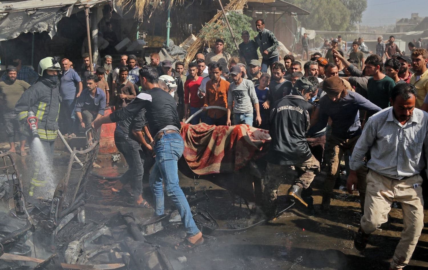 Civil defence members evacuate the body of a victim killed in a car bombing in Afrin, northwest Syria on October 11, 2021. Photo: Bakr Alkasem/AFP