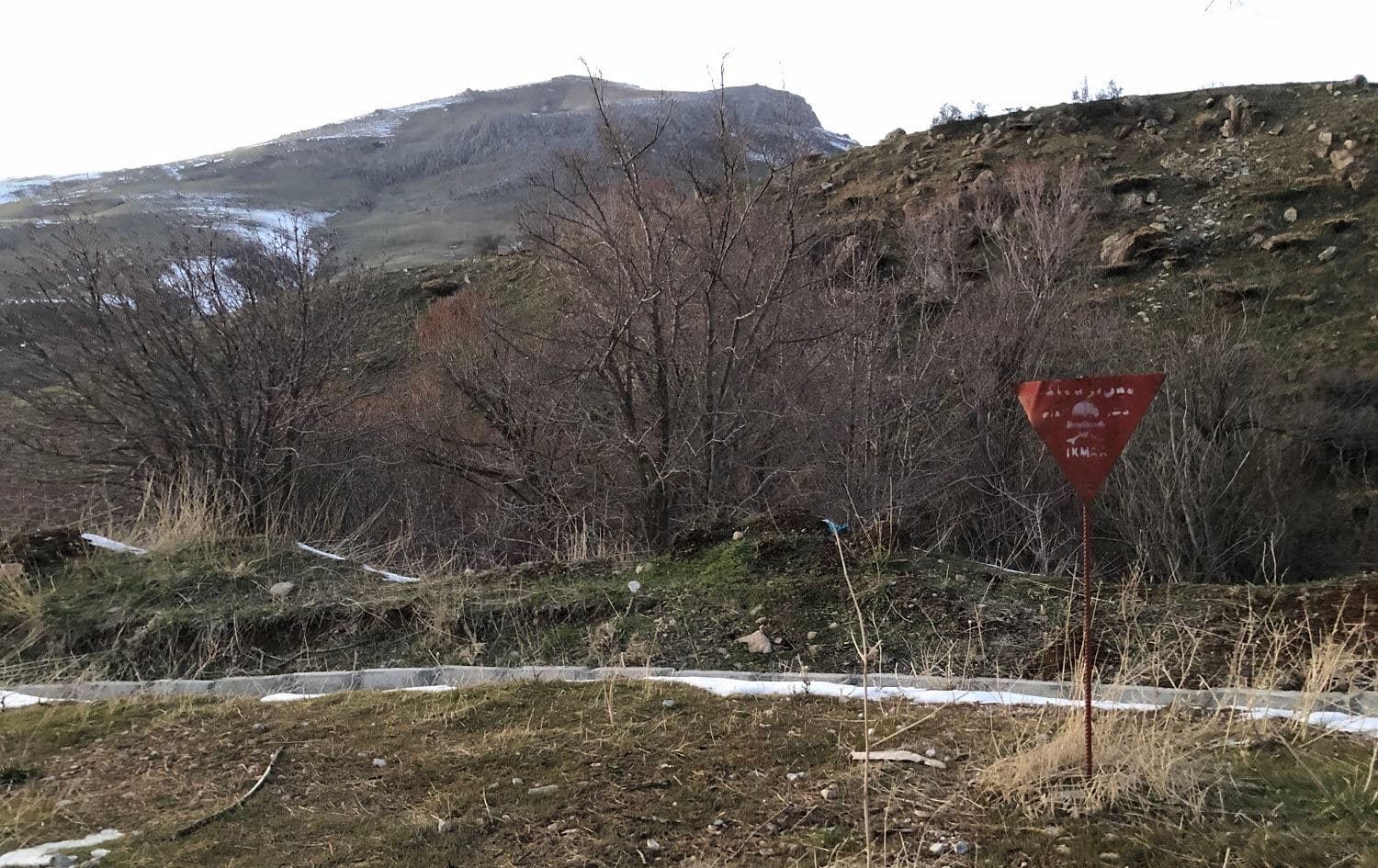 A sign marks a landmine on the side of a road in Halgurd-Sakran National Park near the Kurdistan Region border with Iran in February 2021. File photo: Hannah Lynch/Rudaw