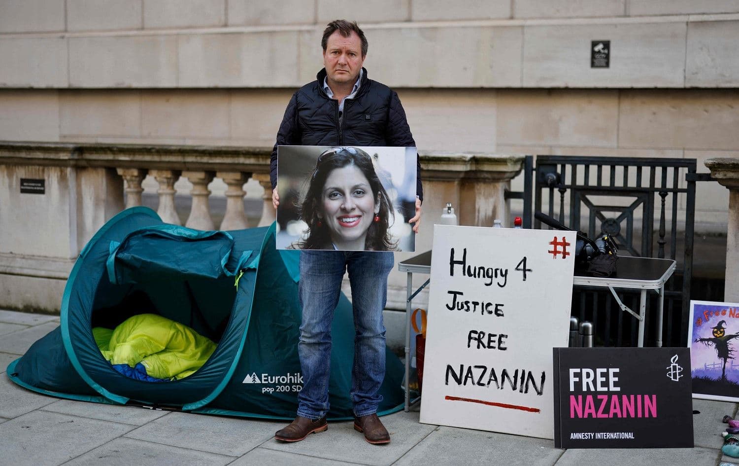 Richard Ratcliffe, husband of Nazanin Zaghari-Ratcliffe, a British-Iranian held in Iran since 2016, holds a picture of his wife outside the Foreign Office in London on October 25, 2021 after beginning a hunger strike to denounce the British government for failing to secure her release. Photo: Tolga Akmen/AFP