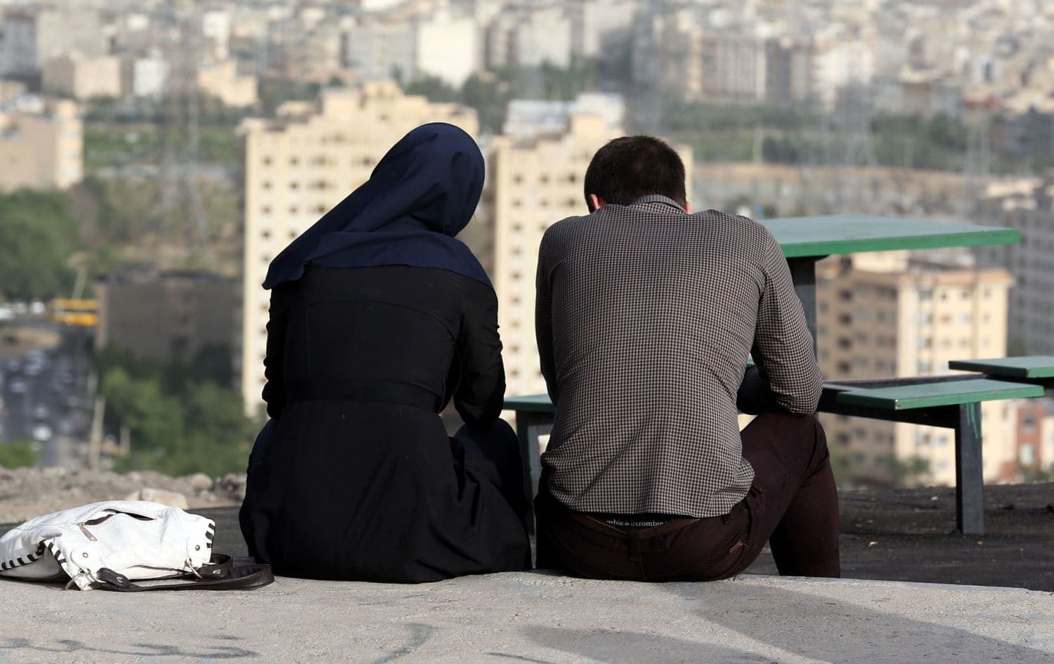 An Iranian couple sit together in the northwestern Shahran neighborhood overlooking Tehran on June 7, 2014. Photo: AFP / Atta Kenare