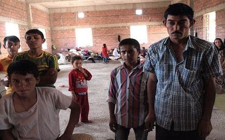 Qasim Said (extreme right), housed with other Yezidi refugees at a makeshift shelter, says he never thought Arabs in Shingal would turn on their Yezidi neighbors. Photo by author.
