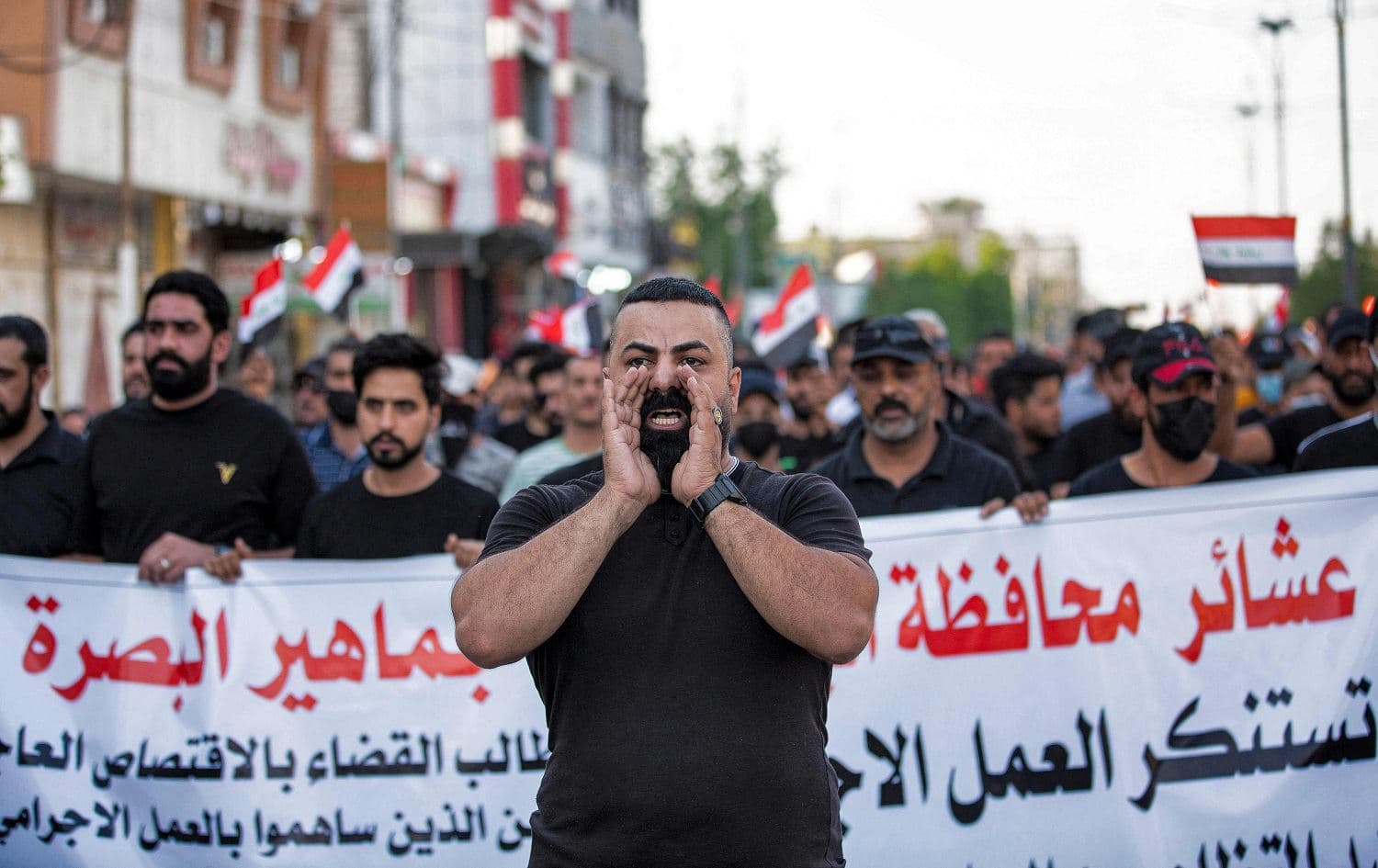 Supporters of the Hashd al-Shaabi paramilitary alliance chant slogans as they demonstrate outside the local headquarters of Iraq's Independent High Electoral Commission in Basra on November 9, 2021, demanding accountability for deaths of protesters outside the Green Zone in Baghdad. Photo: Hussein Faleh/AFP