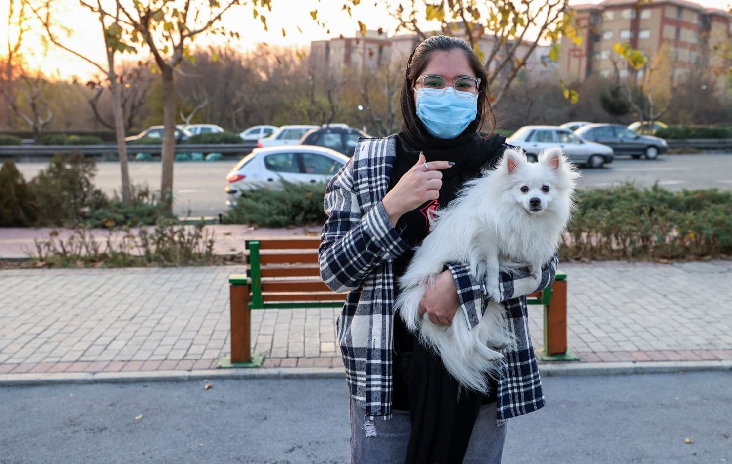 An Iranian woman poses for a picture with her dog at a park in the capital Tehran, on December 7, 2021. Atta Kenare/ AFP