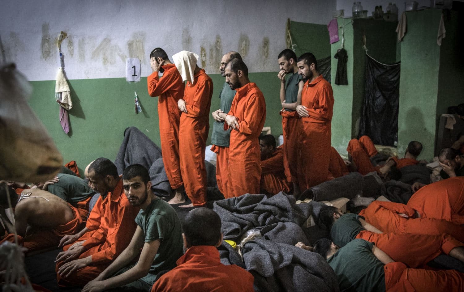 This file photo taken on October 26, 2019, shows men suspected of being affiliated with the Islamic State (IS) group, praying in a cell of the Sinaa prison in the Ghwayran neighbourhood of the northeastern Syrian city of Hasakeh.