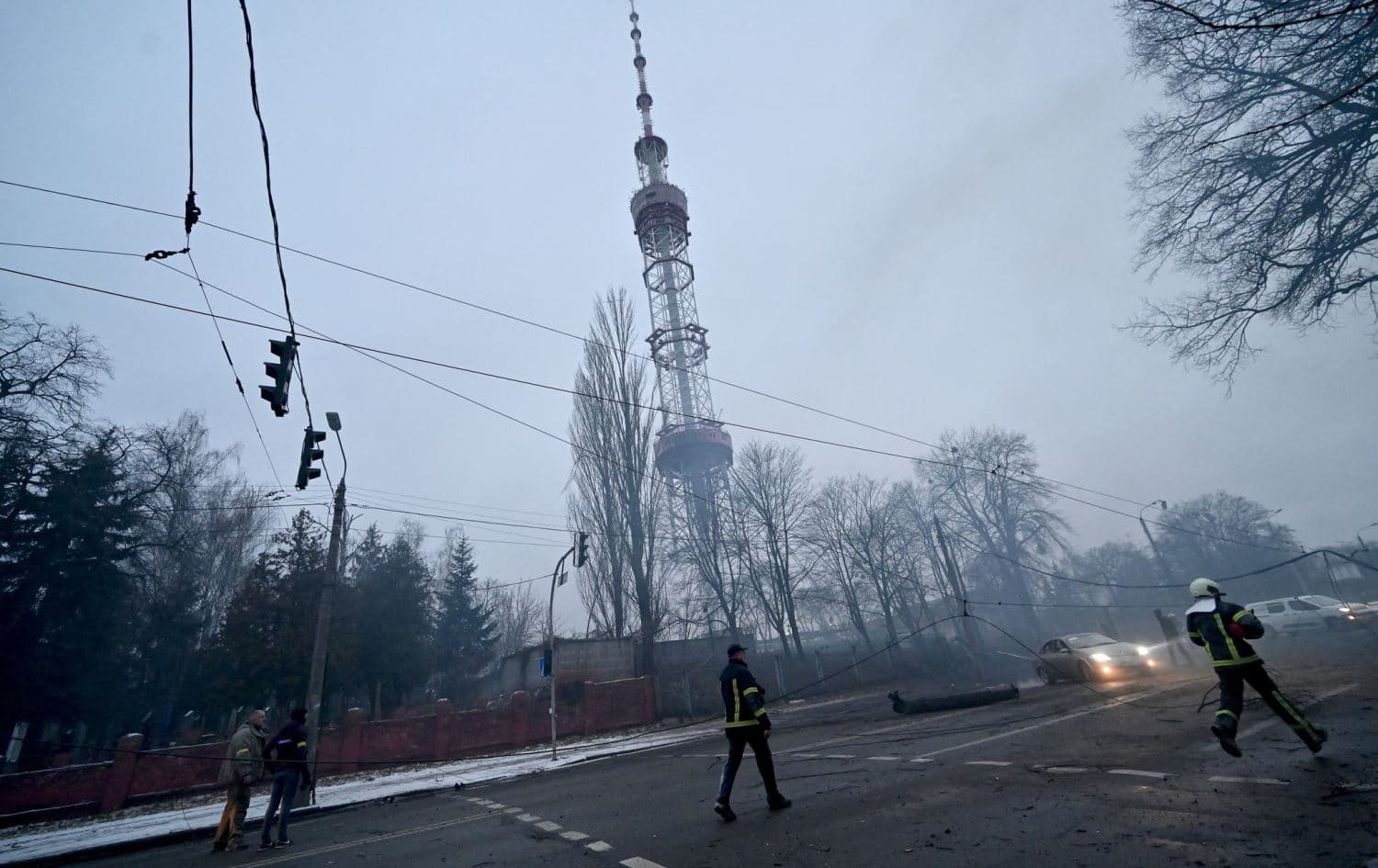 A fireman runs after a Russian airstrike hit Kyiv's main television tower on March 1, 2022. (right). Photo: Sergei Supinsky/AFP