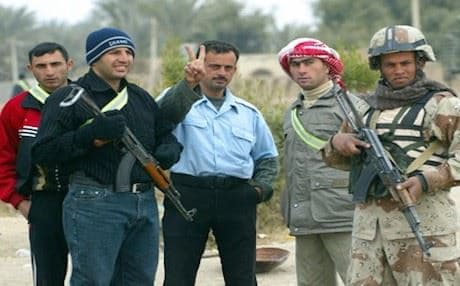 An Iraqi policeman poses for a photo with members of the Sunni Awakening Council, 2008. AFP
