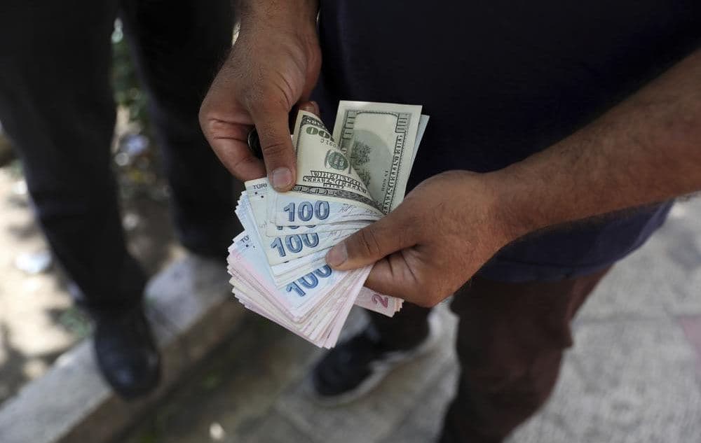 A street money exchanger counts foreign banknotes in Ferdowsi street, Tehran's go-to venue for foreign currency exchange, Iran, on June 12, 2022. Photo: Vahid Salemi/AP