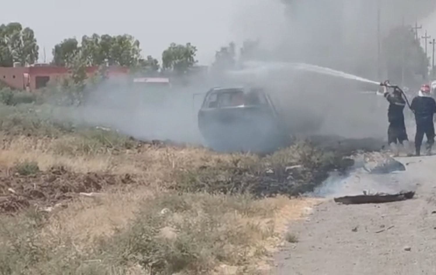 Firefighters extinguishing the car targeted by a drone in Sulaimani's Ranya district on August 1, 2022. Photo: Rudaw