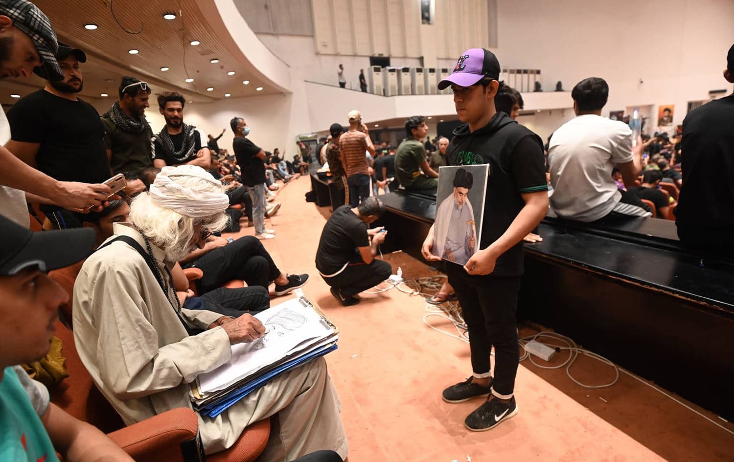 An artist sketches an image of top Shiite cleric Muqtada al-Sadr inside the Sadrist-packed Iraqi parliament on August 3, 2022. Photo: Bilind T. Abdullah/Rudaw