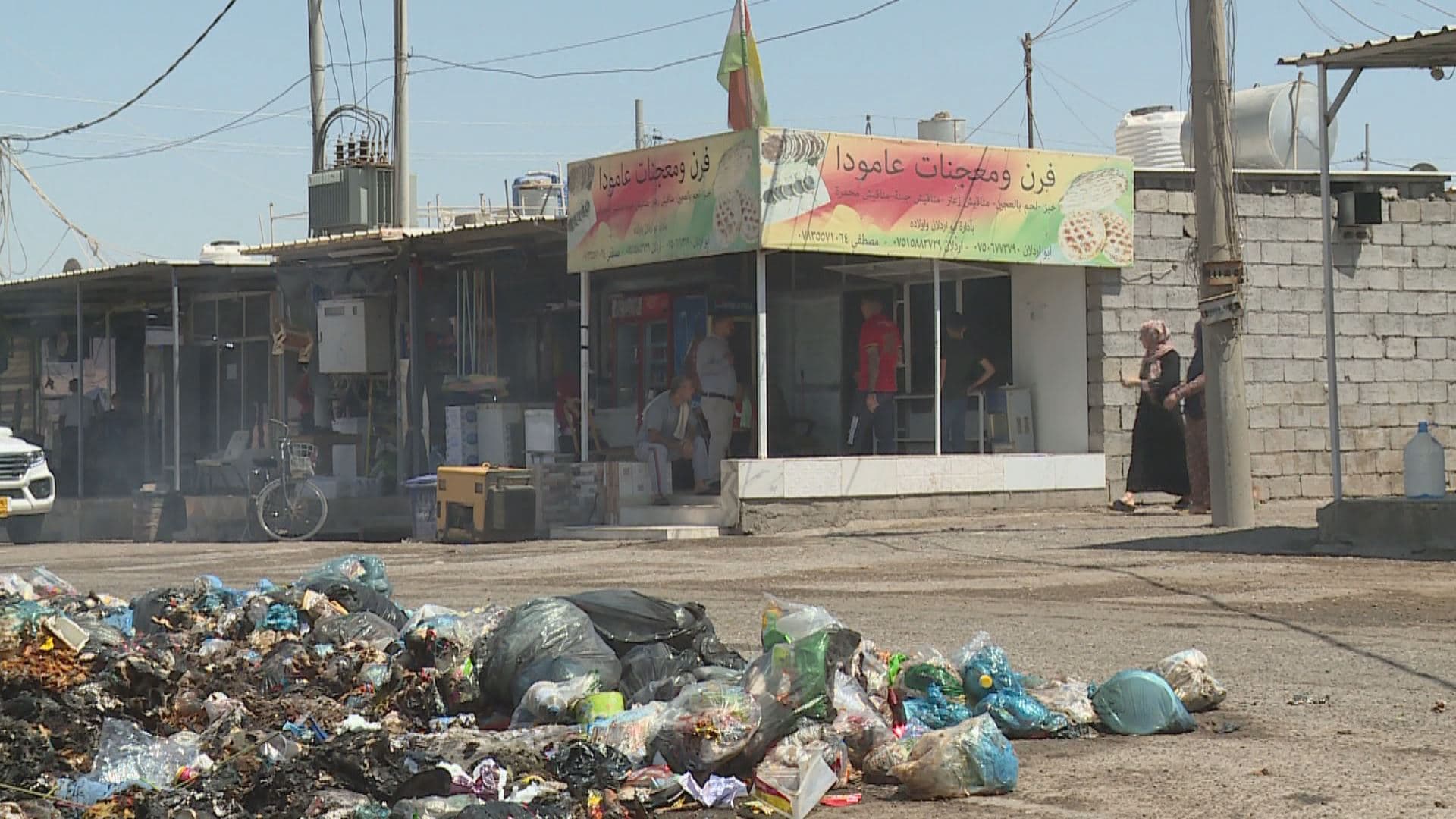 Trash piles up in front of a bakery at Kawergosk refugee camp in Erbil province on August 4, 2022. Photo: Rudaw 