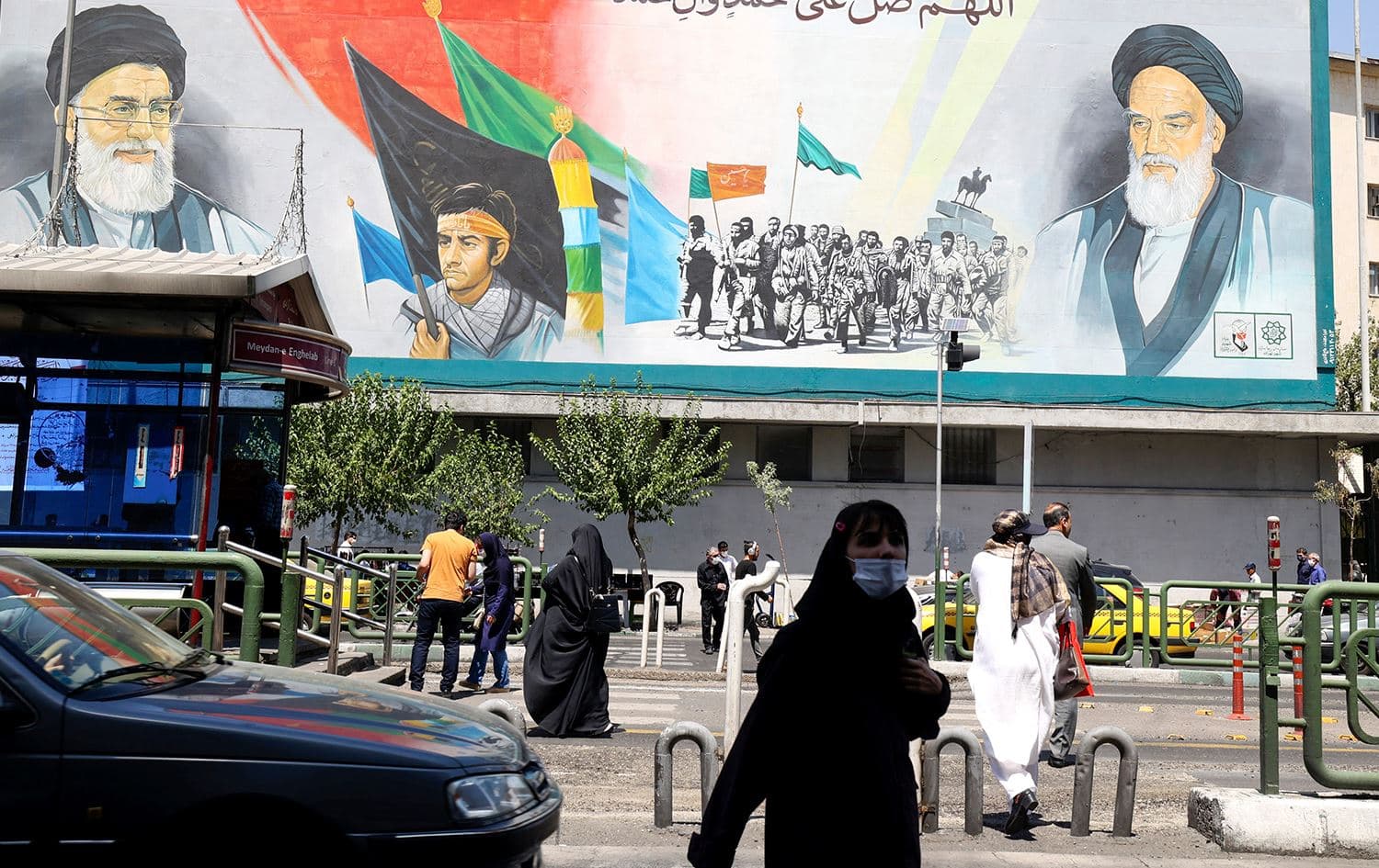 Iranians walk past a billboard bearing the portraits of Iran's Supreme Leader Ayatollah Ali Khamenei (L) and late supreme leader Ayatollah Ruhollah Khomeini in the capital Tehran on August 13, 2022. Photo: AFP