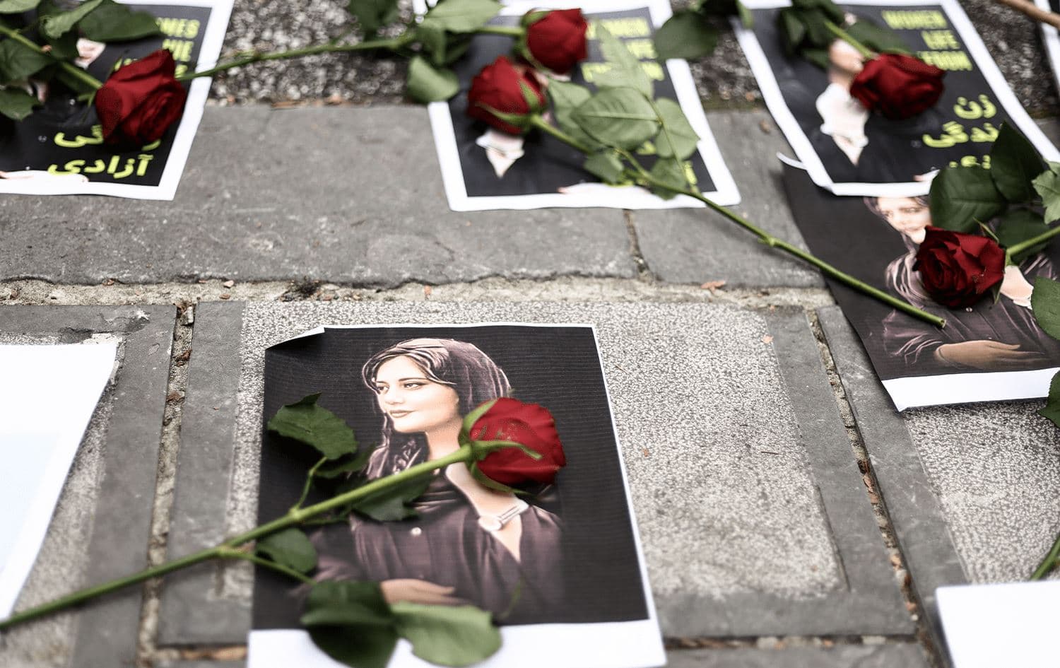 Flowers are seen on a portrait of Mahsa Amini during a demonstration in her support in front of the Iranian embassy in Brussels, on September 23, 2022. Photo: Kenzo Tribouillard/AFP