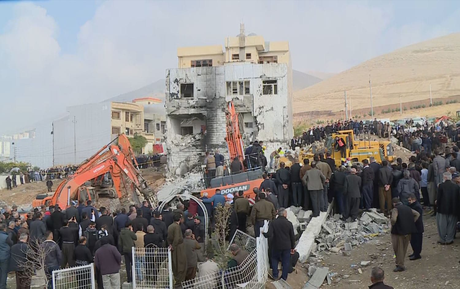 Civilians watch on as civil defense teams and volunteers work hard to uncover the victims' bodies from under the debris a day after the gas explosion in Sulaimani on November 18, 2022. Photo: Rudaw