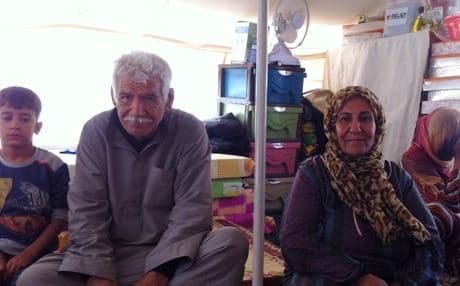 Ibrahim Mahmoud Fahmahy (center) with his family inside the tent that is there home in the Baharka Camp. Photo by author.