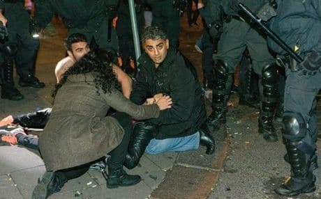 An injured protester gets attention after clashes in Hamburg. Photo: AP.