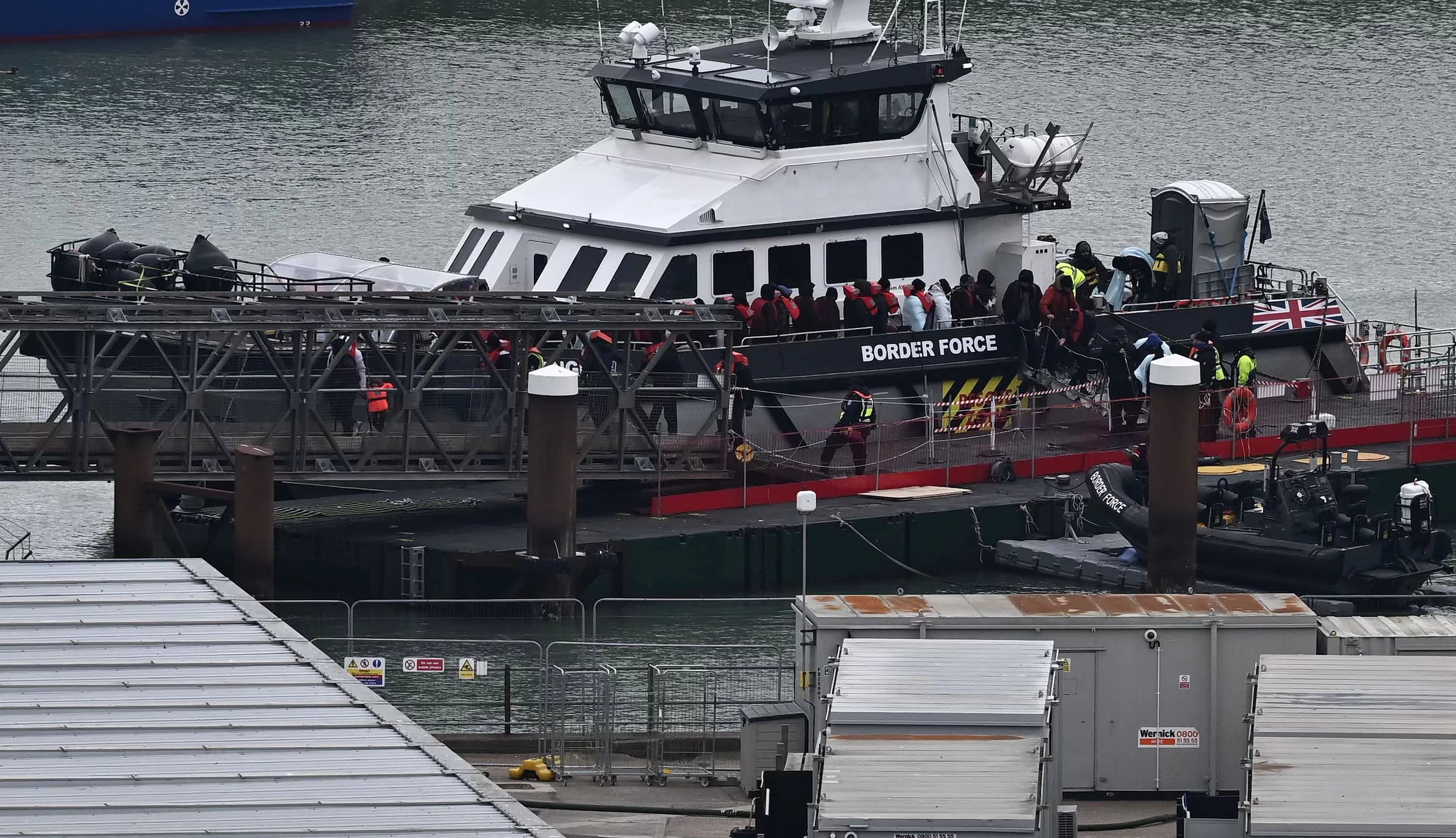 Migrants are escorted ashore from the UK Border Force vessel 'BF Ranger' in Dover, southeast England, on March 6, 2023. Photo: AFP